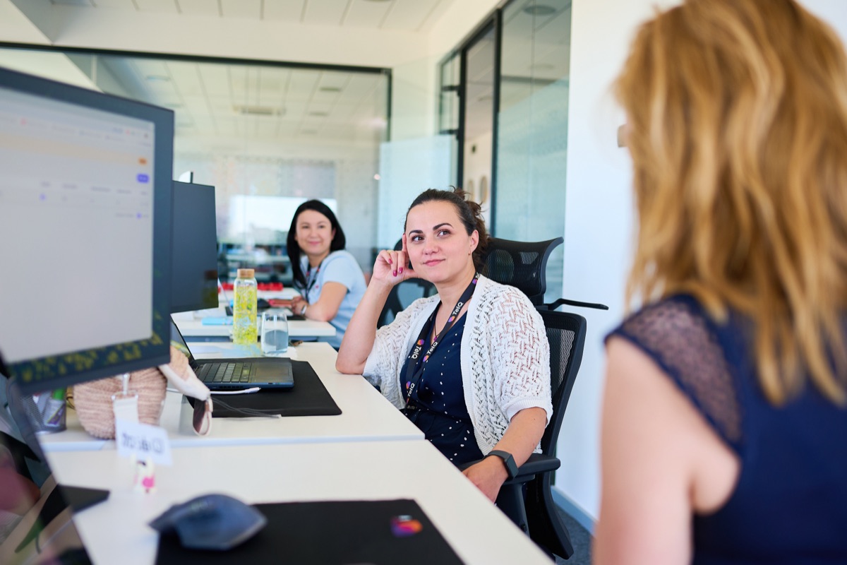 Colleagues chatting at their desk